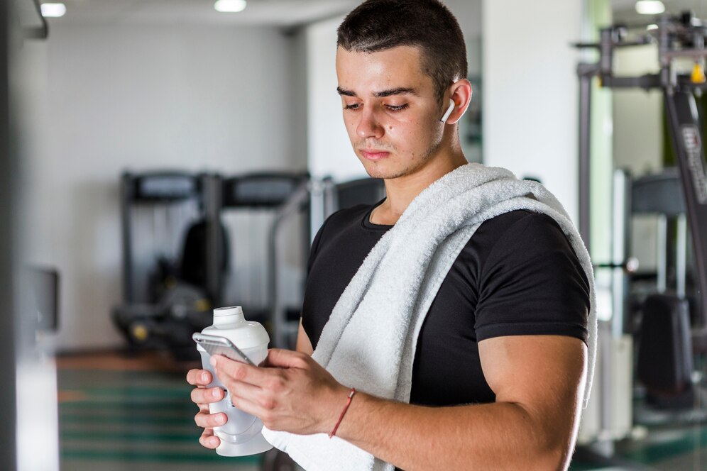 A young personal trainer checking the app during a break from training. Source: Freepik